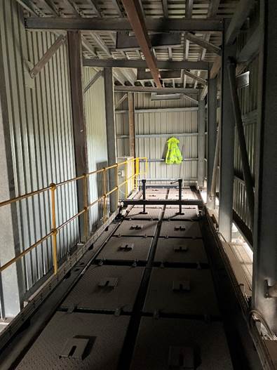 Internal view of a building gantry with hi-vis jacket at the end